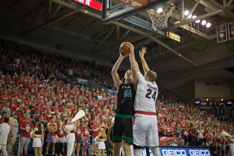 Coach Isaac Neilson in a Utah Valley jersey going up for a post shot against Gonzaga
